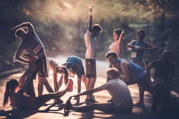 marathon runners stretching and warming up before the race at sunset.